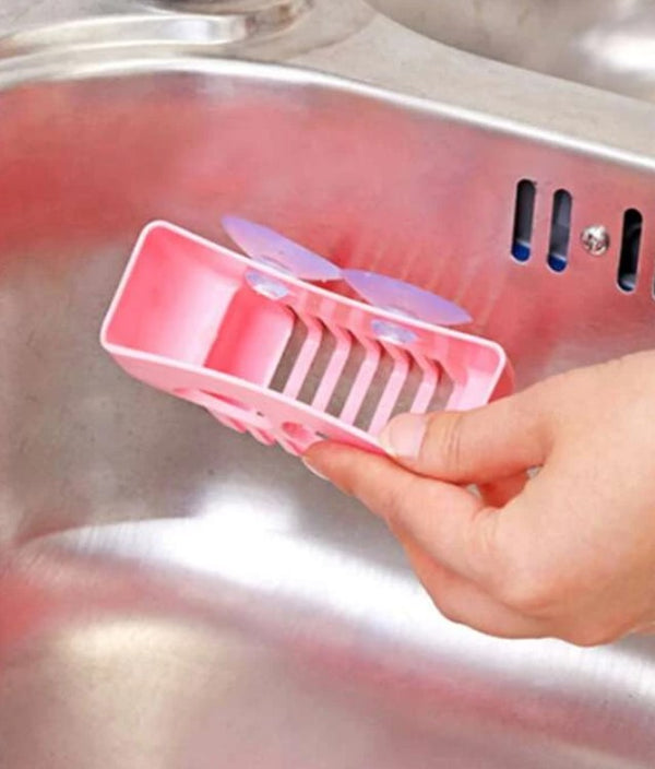 A photo of a pink skull soap saver basket being suctioned to a sink.