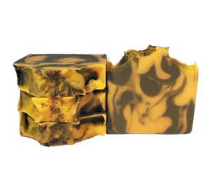 Four bars of soap with brown and bright orange swirls and sprinkles of coconut shell powder on top.