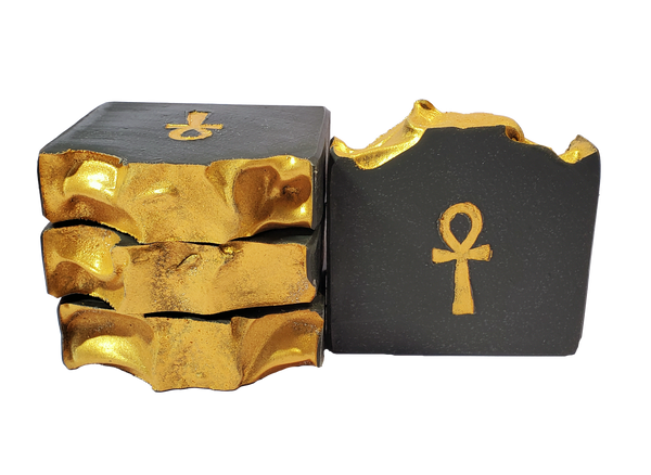 Four bars of Isis soap, which are black with a gold top and a gold ankh.