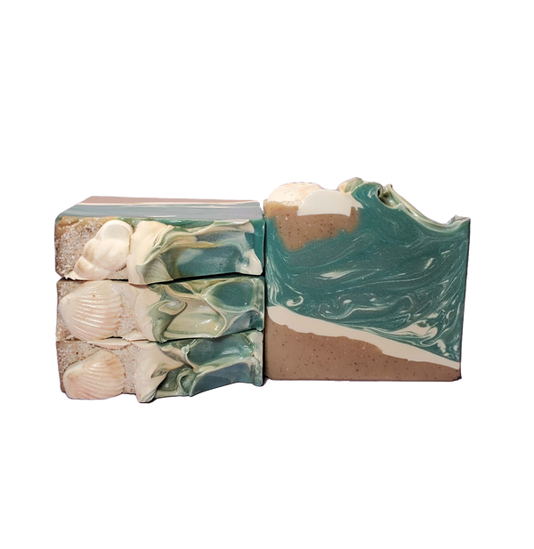 Four bars of Siren soap. The bars look like a beach scene, with a shore and waves. The tops of the bars also look like a shore, with soap shells, salt, and a wave pattern.