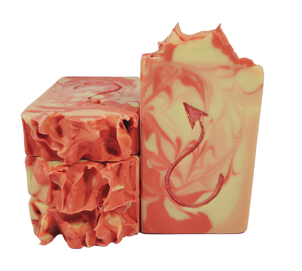 Four bars of Jersey Devil soap, with red, orange, and yellow swirls and a red devil tail on the bar face