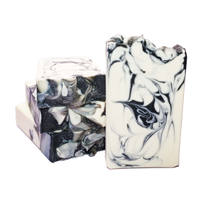 Four bars of Banshee soap. The soap bars are white with black swirls, and silver glitter on top.
