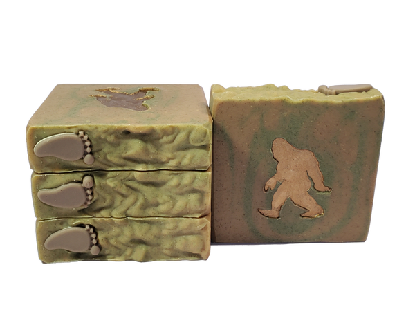 Four bars of Bigfoot soap, brown and green with a brown footprint on top and a brown silhouette of Bigfoot on the bar face