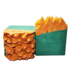 Two bars of Dumpster Fire soap. The soap bars look like a side view of a green dumpster with glittery orange flames coming out of the top.