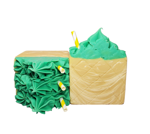 Four bars of Piña Colada soap. Each bar is yellow with white swirls and a bright green, pointed top with a yellow and white striped paper straw. A diamond pattern appears on the bars to resemble the rind of a pineapple.