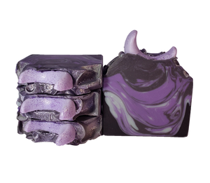 Four bars of The Moon soap. Each bar contains purple, gray, and black swirls and is topped with a light purple crescent moon and purple glitter.